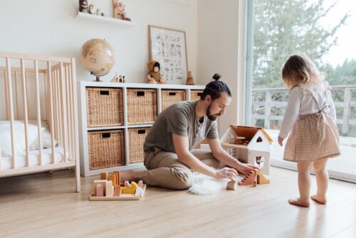 dad playing on floor with children